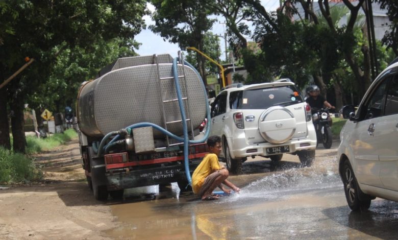 "Mencuci" jalan raya dan mobil-motor dari genangan lumpur Dilakukan PT Triconville di jalan raya Kudus- Jepara Desa Papringan Kaliwungu Kudus, Minggu 20/11/2022 Foto Sup